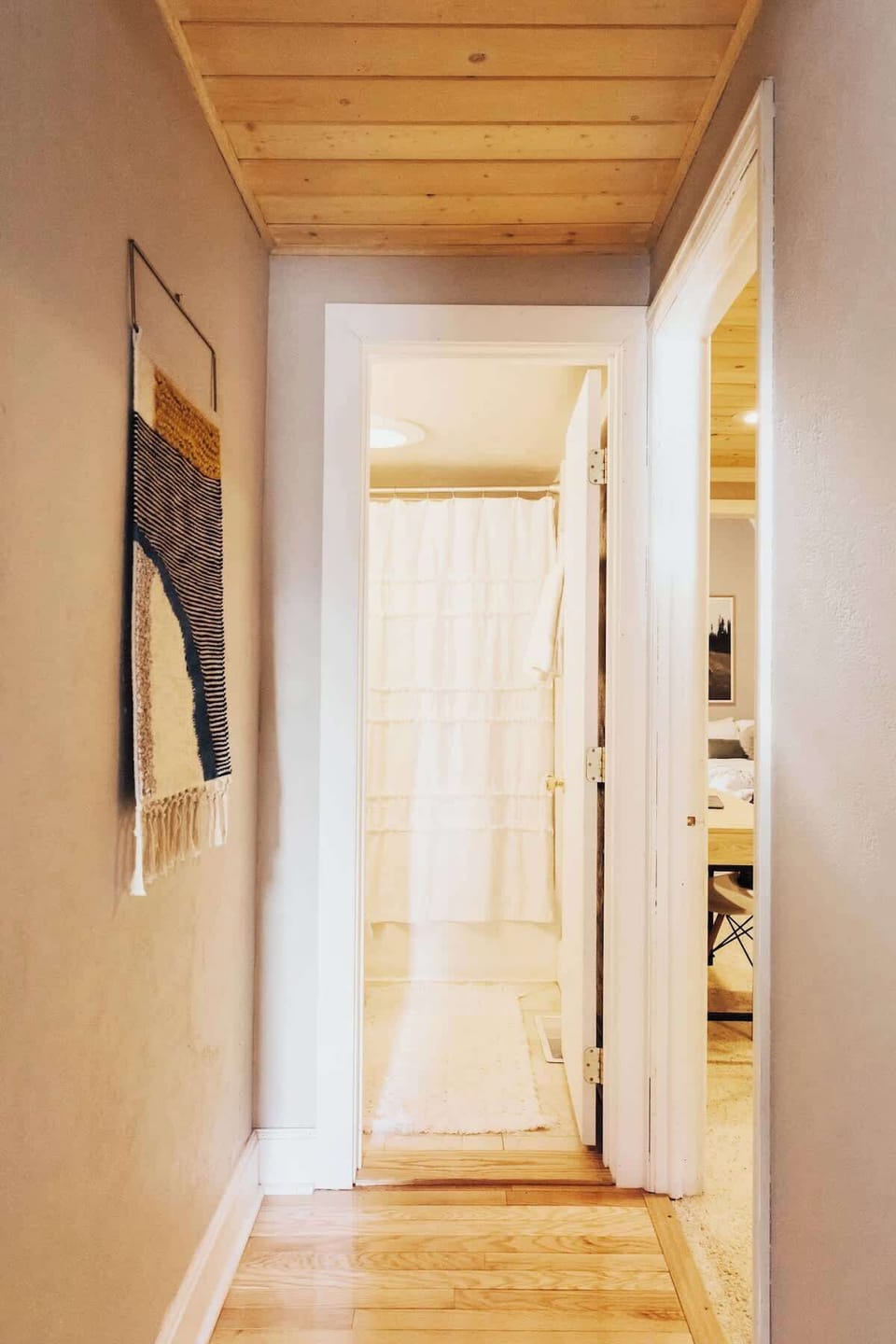 Hallway from kitchen; full bathroom ahead, game room to the right