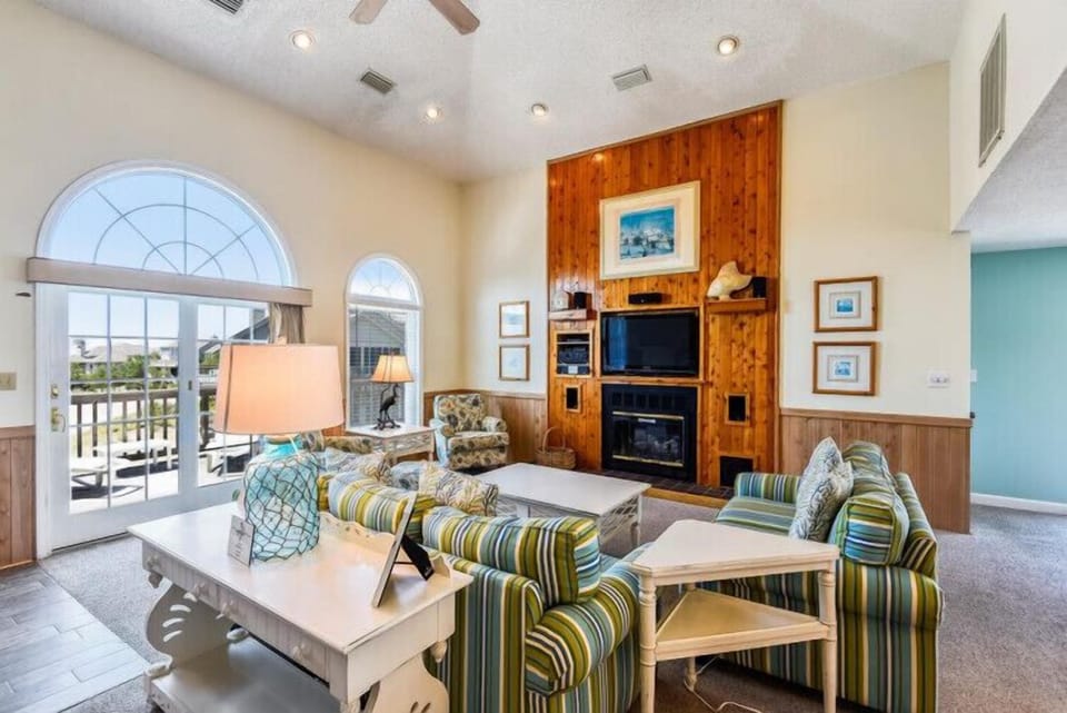 Step into your bright, coastal retreat with soaring ceilings and arched windows that frame your private balcony. Relax by the fireplace, gather around the cozy seating, and enjoy your home away from home.