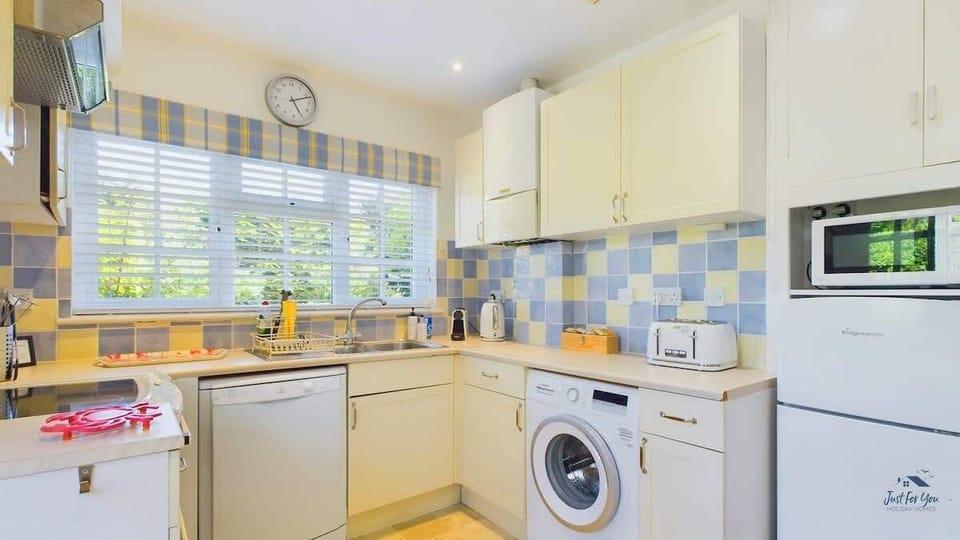 Detail of kitchen appliances at White Roses including fridge freezer, microwave, Nespresso machine and dishwasher.
