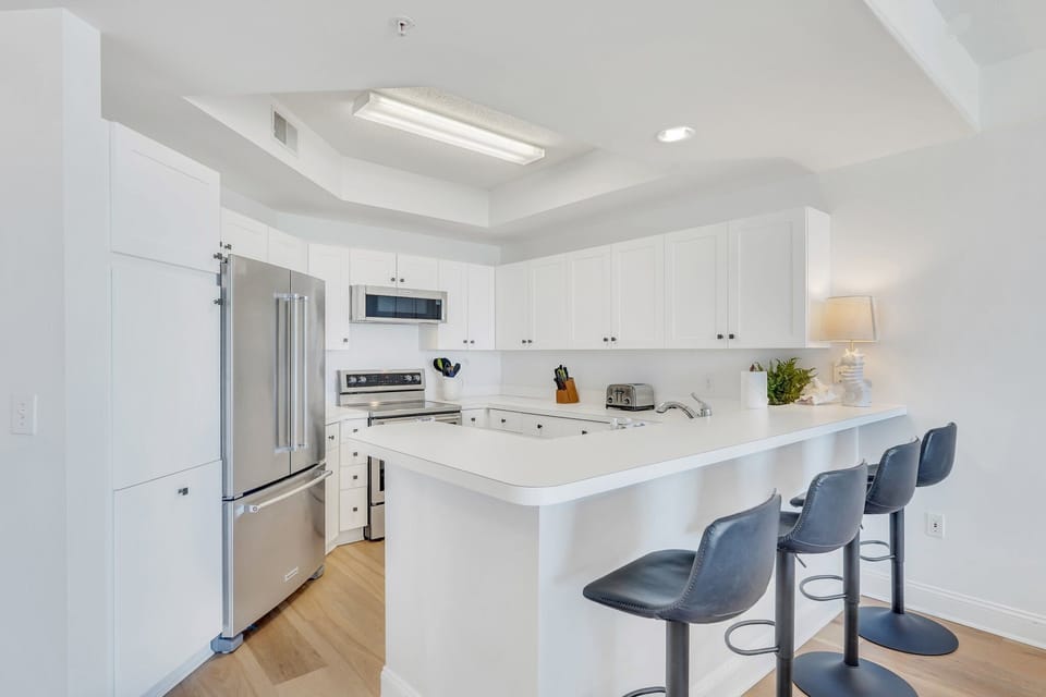 The kitchen is fully equipped with countertop stools for additional seating.