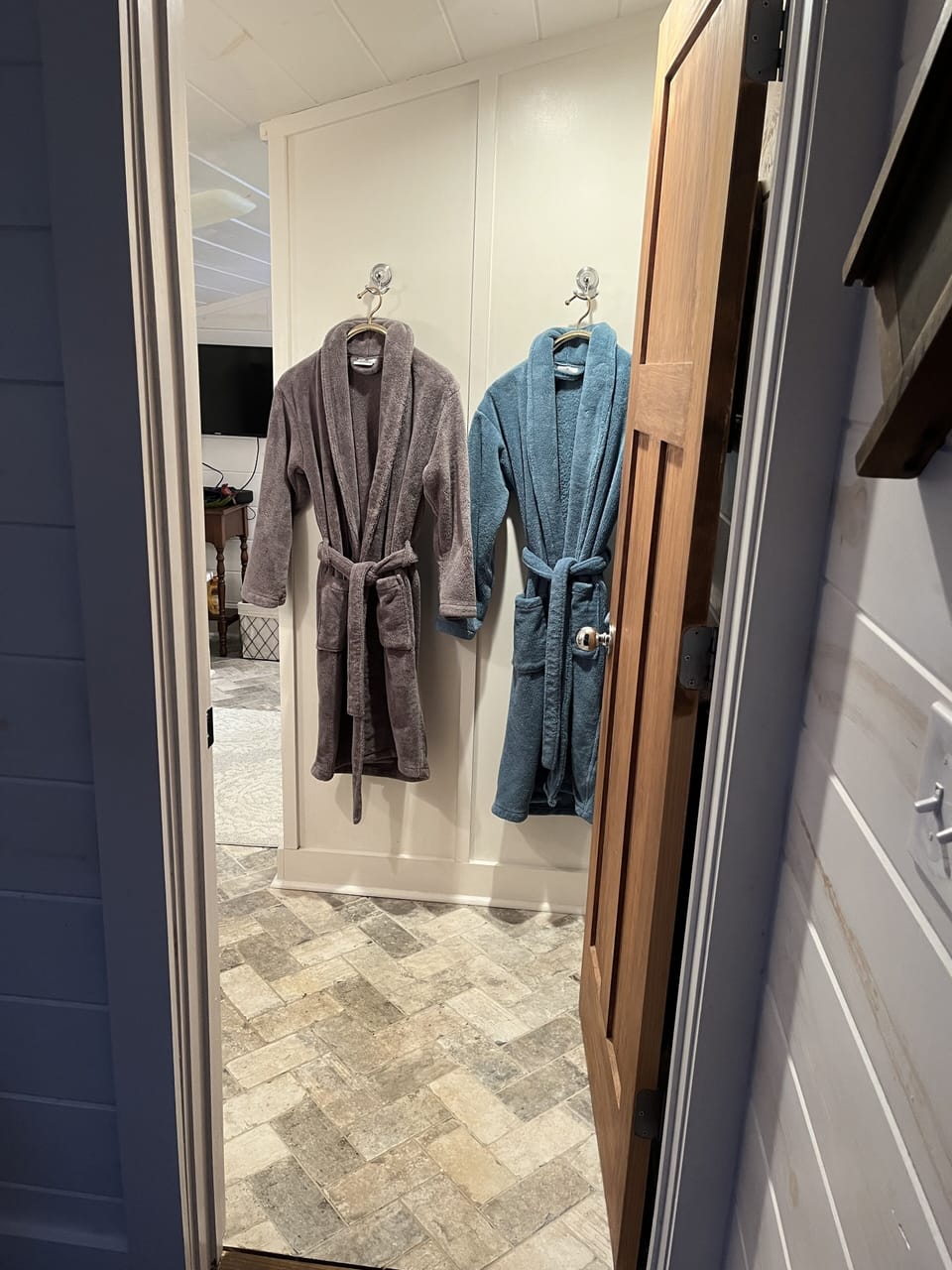Entrance to bathroom complete with robes, its own heater, AND heated floors