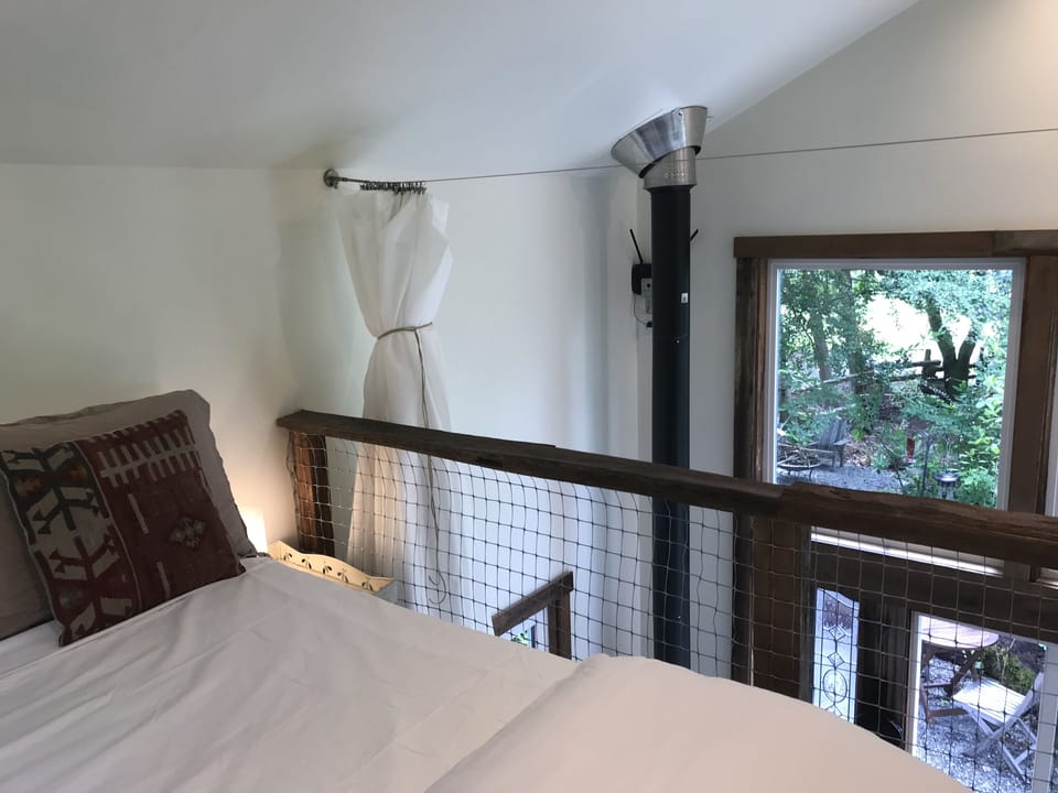 View from upstairs bed through forest, across field, and a bit of Puget Sound. 