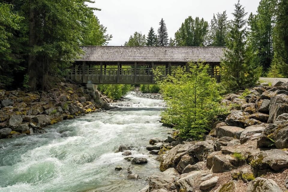 - Scenic river view with charming covered bridge surrounded by pines  
- Peaceful spot to stroll and enjoy Whistler’s natural mountain beauty  
- Flowing water and forest trails create a perfect photo backdrop  
