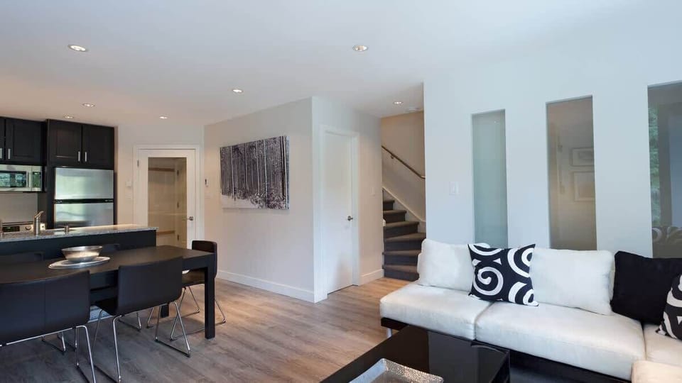 - Open-concept living and dining area with chic modern furnishings  
- Natural light fills the space creating a bright, inviting atmosphere  
- Perfect for group gatherings and cozy evenings by the fire 