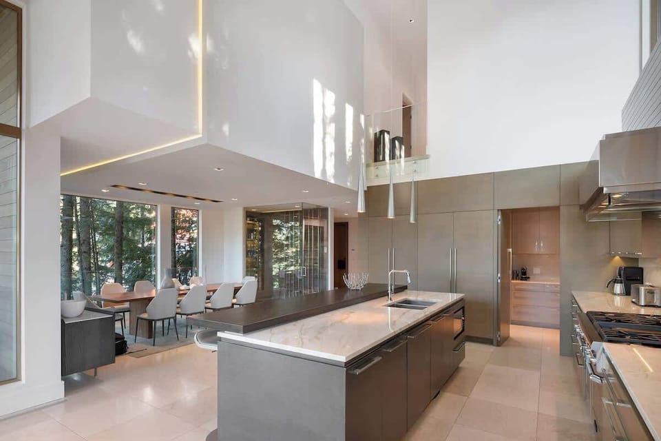 - Contemporary kitchen design with tall ceilings and open dining access  
- Large island for social cooking and breakfast gatherings  
- Perfect mix of style, function, and forest-facing serenity  