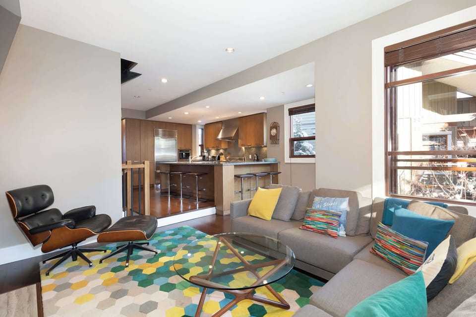 - Bright living room with colorful décor and plush seating  
- Open layout flowing into kitchen and dining for easy hosting  
- Relax after adventures with mountain charm and sunlight  
