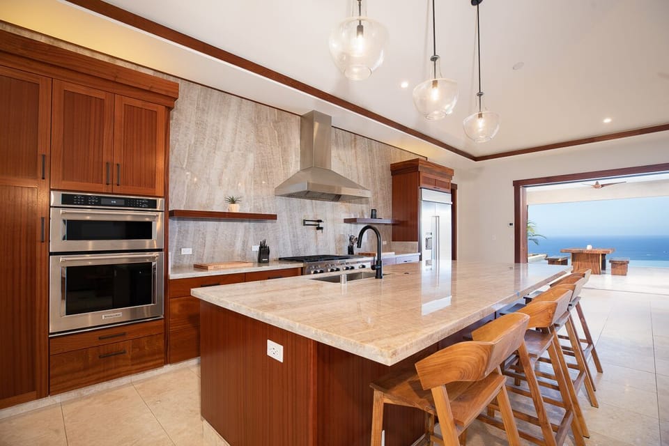 Prepare meals with ease in the kitchen equipped with a six-burner commercial cooktop, convection oven, and high-end appliances.