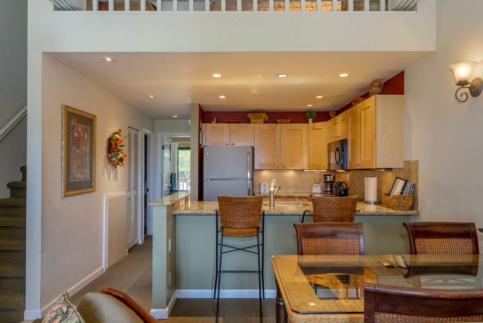 Gather around this inviting breakfast bar where granite countertops, warm wood cabinets, and stainless appliances create the perfect space for your morning coffee and memorable conversations.