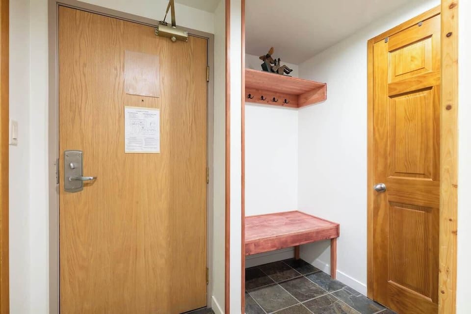 - Warm entryway with ski storage and wooden accents  
- Whistler condo designed for comfort and convenience  
- Drop your gear and relax after your mountain day  