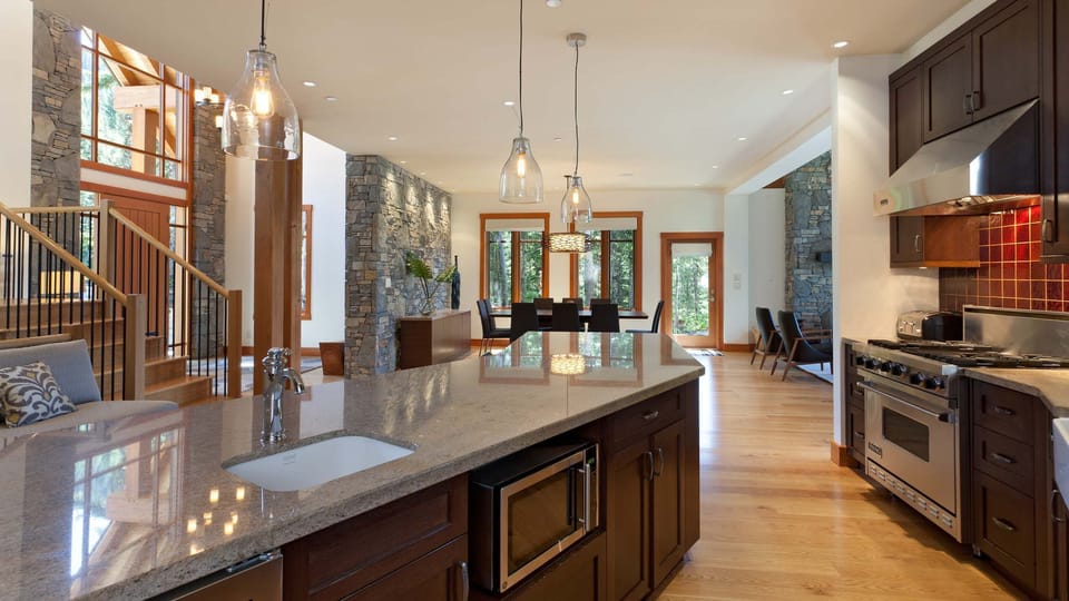 - Spacious kitchen with large island and sleek pendant lighting  
- Open layout connects dining and living for easy entertaining  
- Perfect for group cooking and cozy mountain meals  