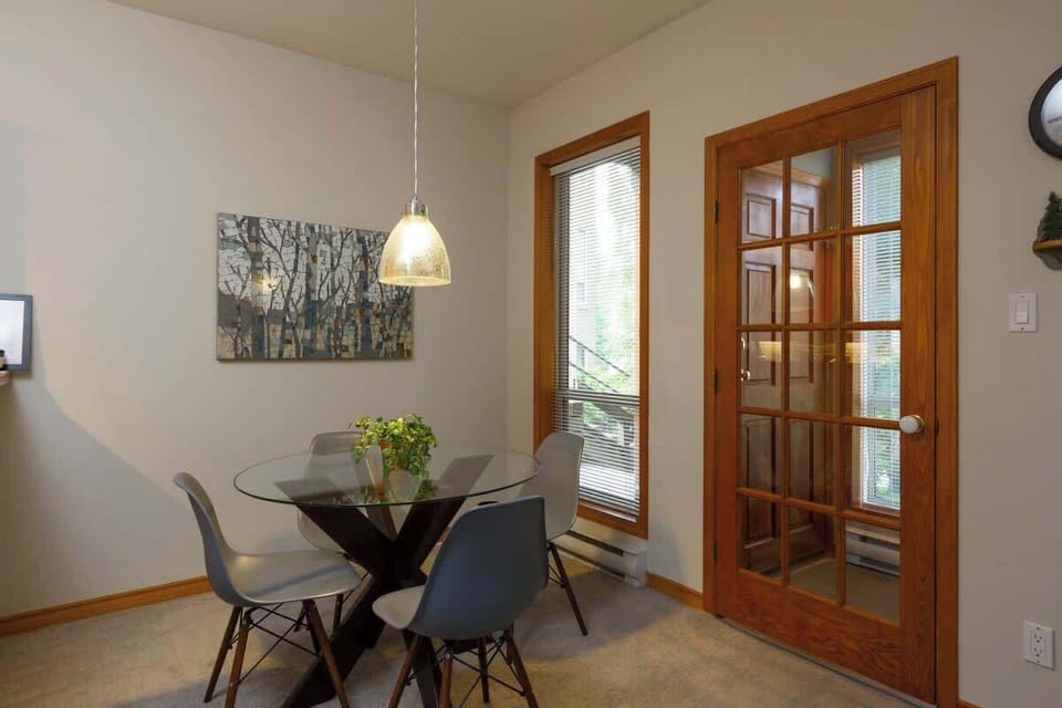 - Bright dining nook with glass table and modern pendant light  
- Forest views and warm wooden trim enhance alpine elegance  
- Perfect Whistler vacation rental for cozy shared meals  
