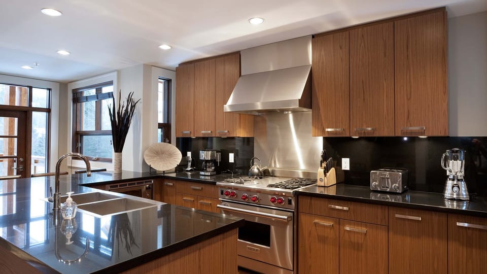 - Sleek kitchen with dark stone countertops and rich wood cabinetry  
- Equipped with premium stainless steel appliances for easy cooking  
- Ideal for group meals and cozy winter breakfasts 
