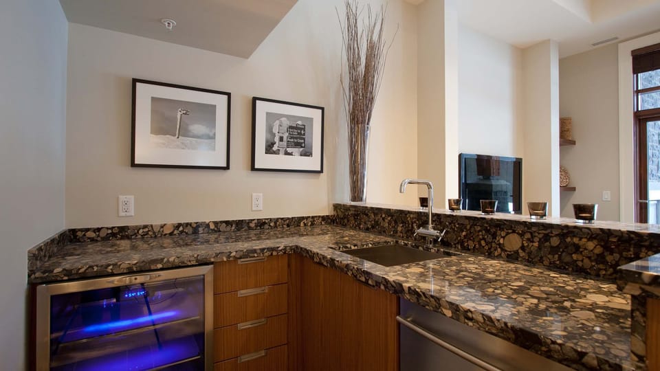 - Granite bar with rich wood cabinetry and modern wine fridge  
- Perfect corner setup for evening drinks or morning coffee moments  
- Adds a stylish touch to your mountain retreat stay  