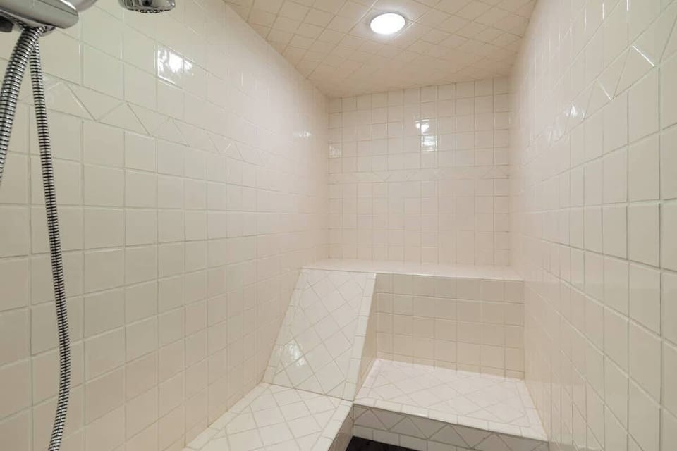 - Bright tiled steam shower offering ultimate post-ski rejuvenation space  
- Built-in bench and rainfall showerhead create a calming spa experience  
- Ideal for warming up after snowy Whistler adventures outdoors  