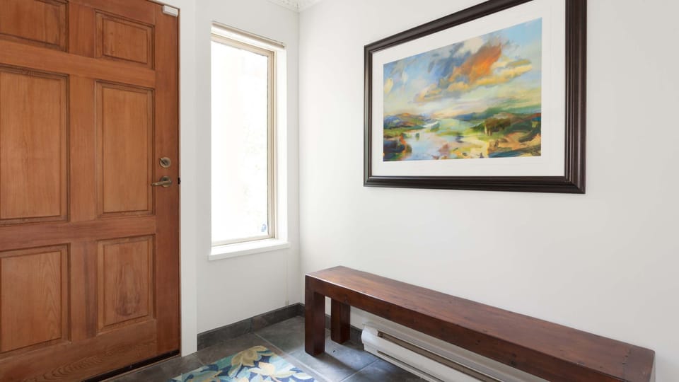 - Welcoming entryway with bright natural light  
- Elegant bench and colorful wall art accent  
- Inviting start to your Whistler mountain stay 