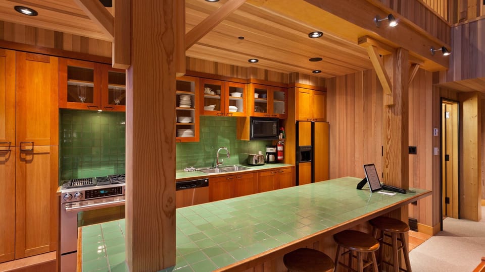 - Fully equipped kitchen with green tile backsplash and premium appliances  
- Long breakfast bar ideal for morning coffee before hitting the slopes  
- Wooden interiors blend warmth and functionality in a true alpine style  