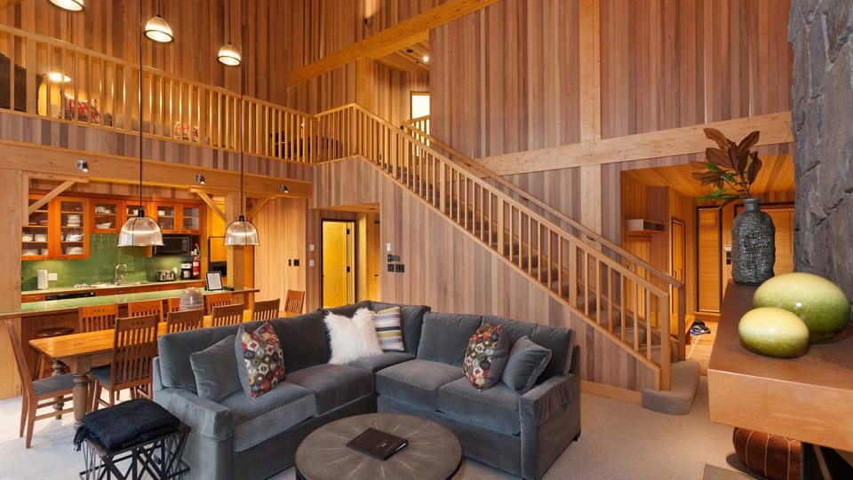 - Soaring wood-paneled ceilings and a grand stone fireplace create a warm mountain escape  
- Spacious open-concept living with plush seating for après-ski relaxation  
- Gather for cozy nights by the fire in this Whistler mountain chalet  

