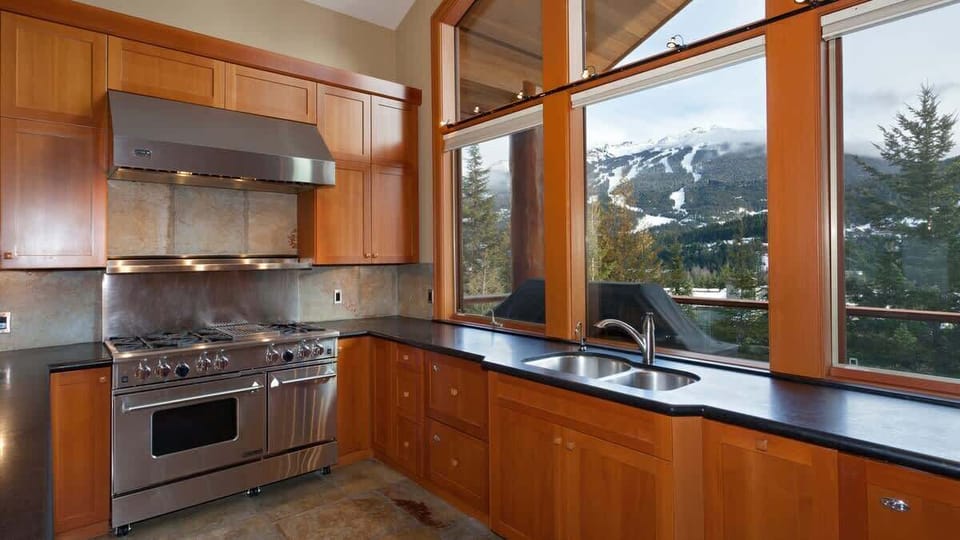- Gourmet kitchen with mountain views and premium stainless steel appliances  
- Granite counters and wooden cabinetry create a warm alpine cooking space  
- Cook with scenery as stunning as the meals you’ll prepare here 