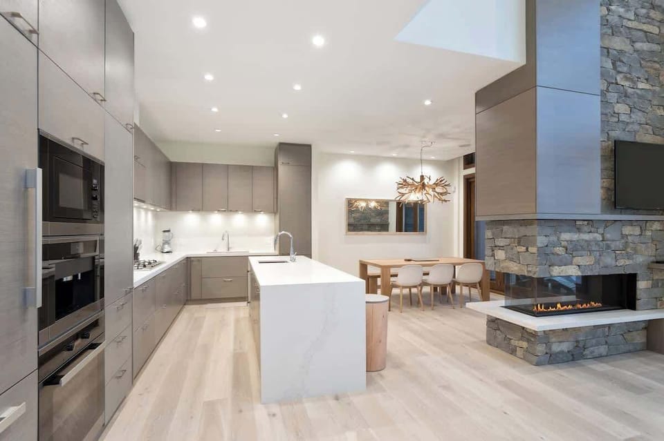 - Elegant open-concept kitchen and dining beside a stone fireplace  
- Modern lighting and natural textures create a warm mountain vibe  
- Ideal space to cook, dine, and relax after a day outdoors  