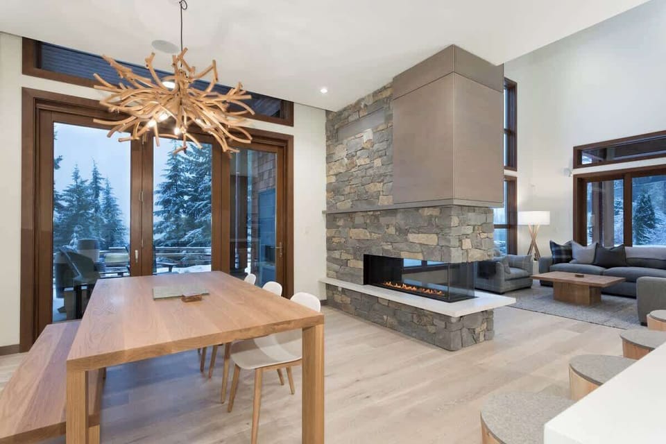 - Open dining area with natural wood table and artistic chandelier  
- Warm fireplace connects dining and living spaces beautifully  
- Ideal spot for shared meals and cozy evenings by the fire  