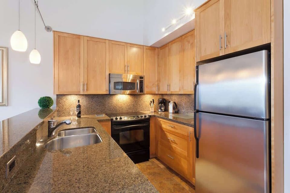- Modern kitchen featuring stainless steel appliances and granite countertops  
- Fully equipped cooking space with wooden cabinetry and bar seating  
- Great for preparing hearty meals after exploring Whistler 