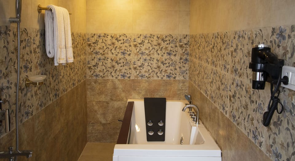 Deluxe Suite | Bathroom | Shower, rainfall showerhead, slippers, towels
