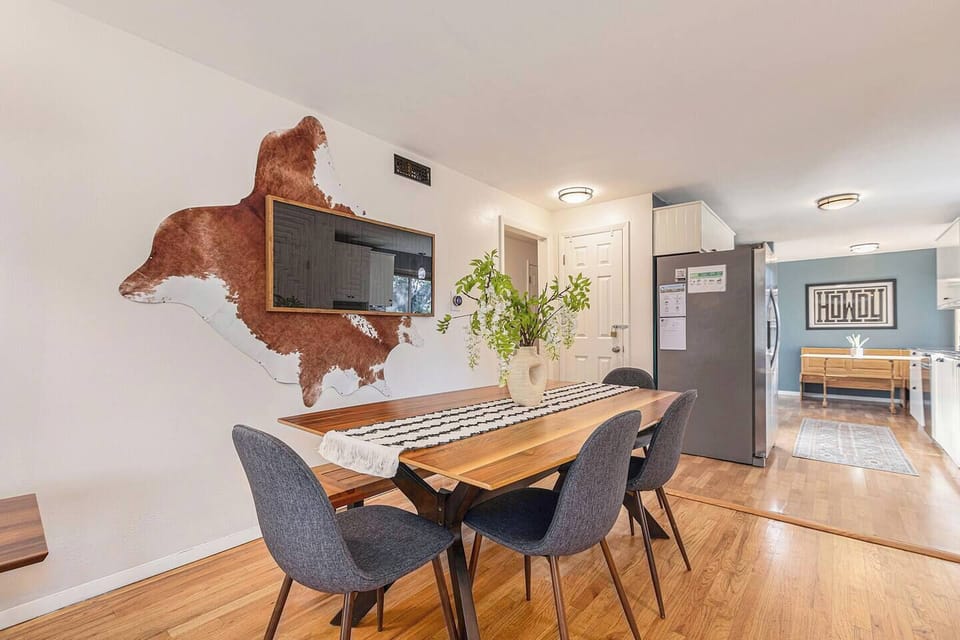 - Modern dining room with a live edge wood table, seating for six, and a bold wall art display
- Bright and airy with natural light and stylish decor accents
- Great for family meals, game nights, or remote working

