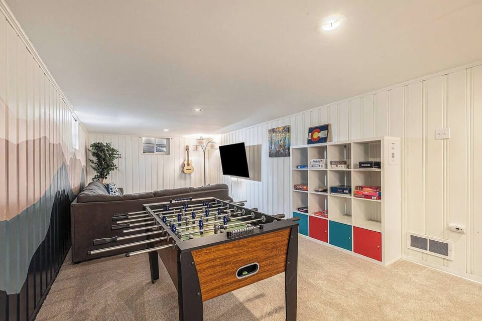 - Fully stocked game room with foosball table, board games, and a mounted TV for entertainment
- Bookshelves and guitars add charm to this cozy space for groups or families
- Relax and play in this fun filled retreat after a day out