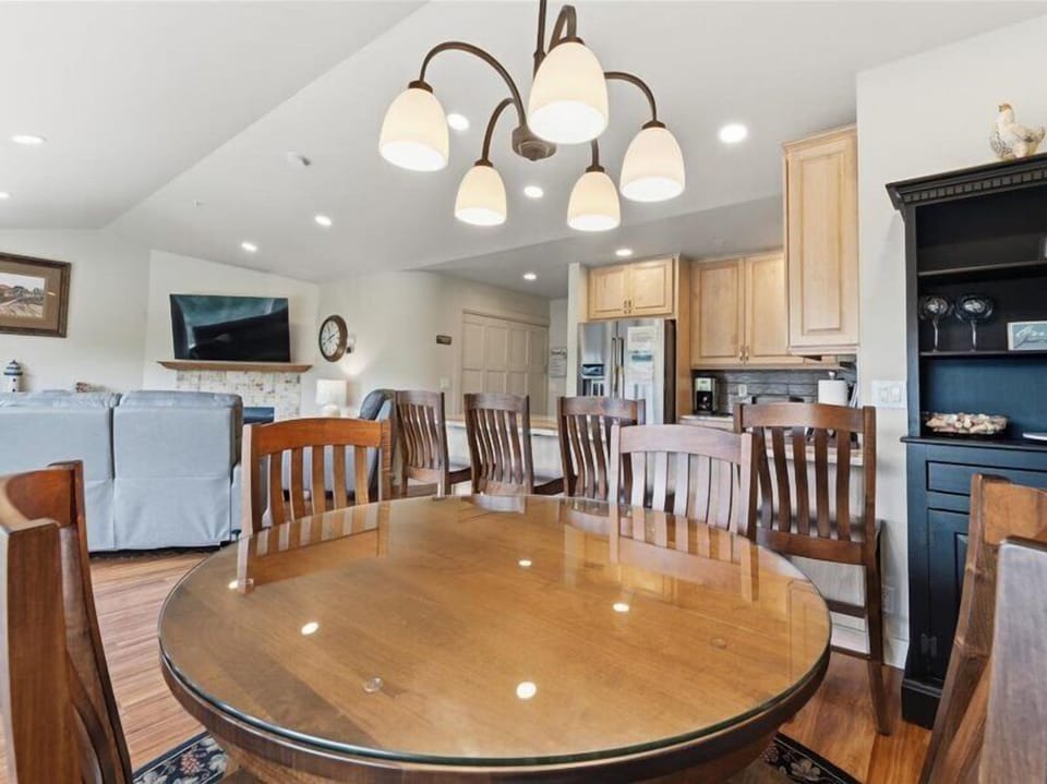 Gather around the spacious dining table under charming chandelier light, with a full kitchen ready for your group meals and a cozy living area just steps away for post-dinner relaxation.