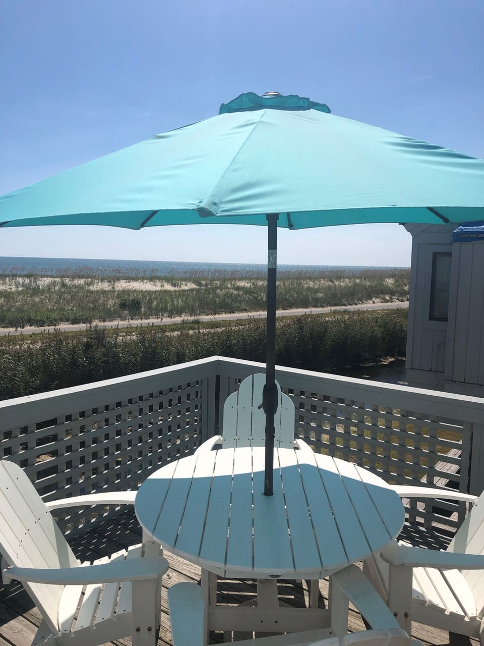 Outdoor dining on porch at villa's entry w/ ocean views