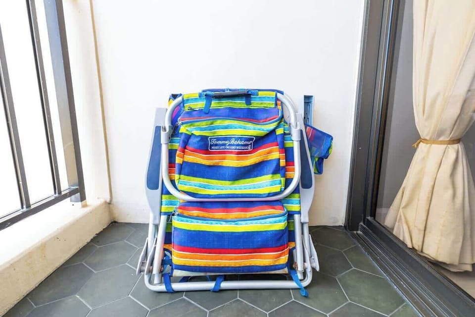 Folded colorful beach chairs stored on the balcony with tiled flooring.