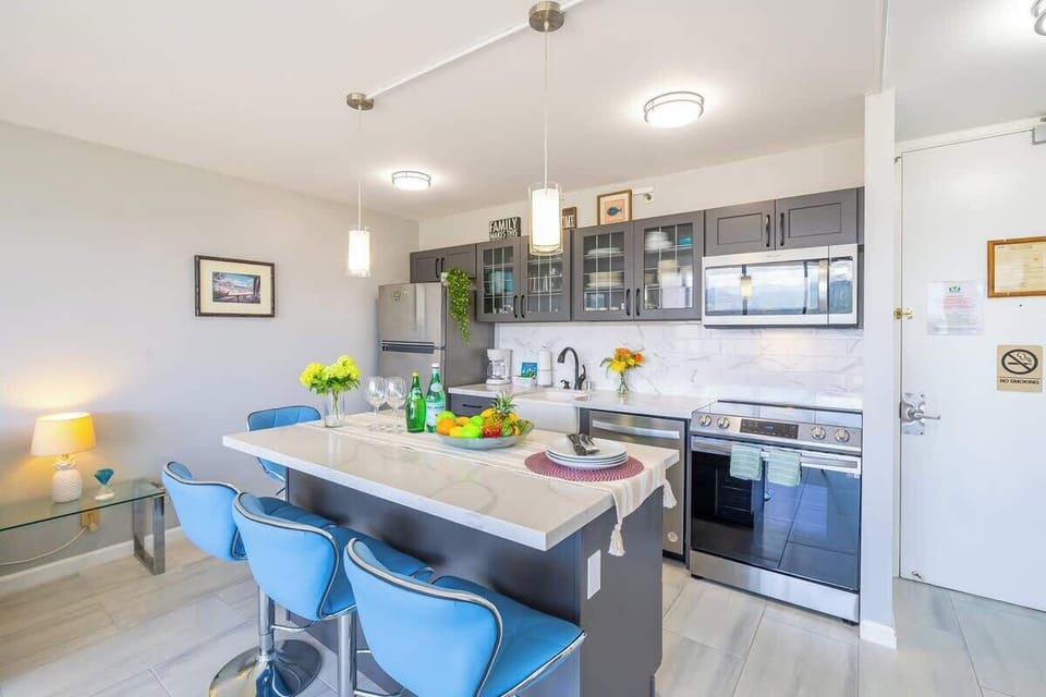 Modern kitchen with a marble island and blue bar stools for casual dining.