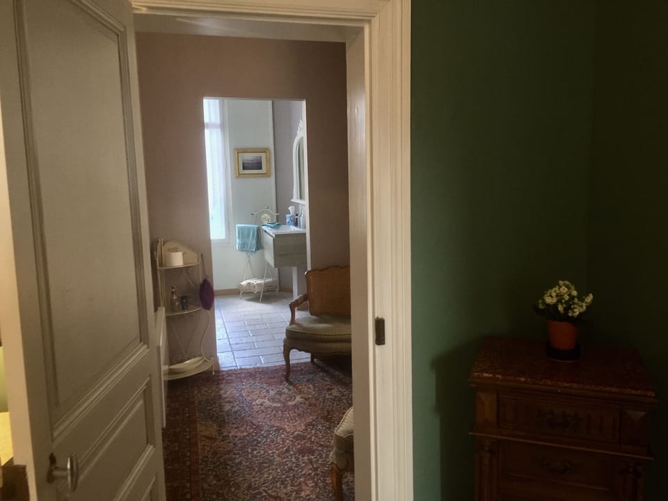 A view of the second seating area & private bathroom of Chambre Peron.