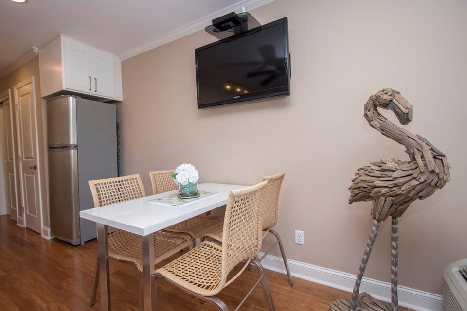Seaside Villas 238 - Dining Area - The large, wall-mounted flat-screen TV is centrally placed so it can watched from the dining table or the sofa.