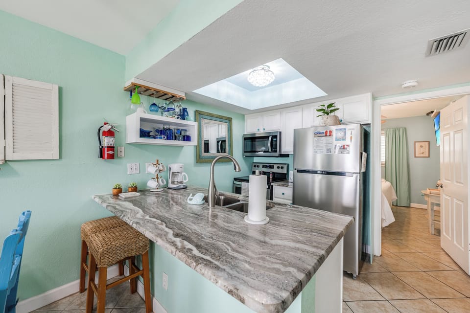 Prepare meals in your bright kitchen featuring granite countertops, stainless steel appliances, and a charming skylight that fills the space with natural light.