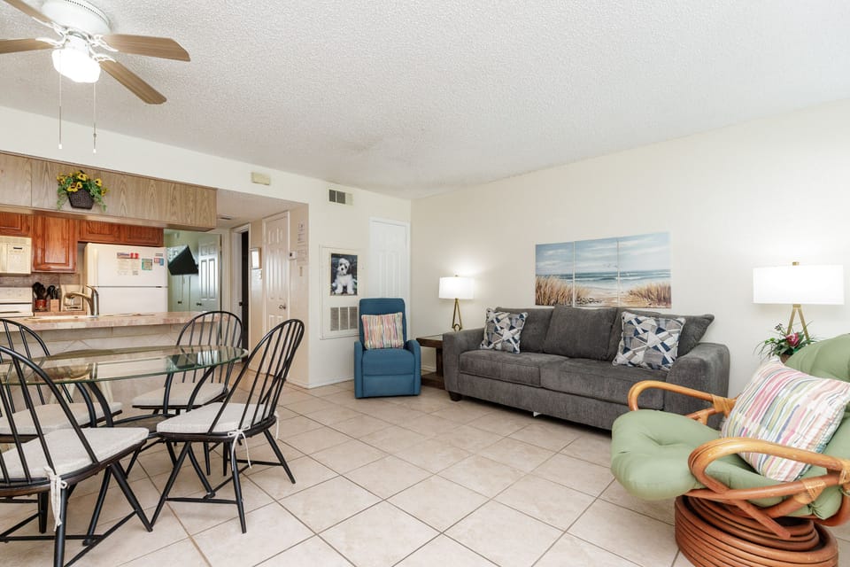 Relax in this bright, open living space with cozy seating and coastal artwork welcoming you home after beach adventures.