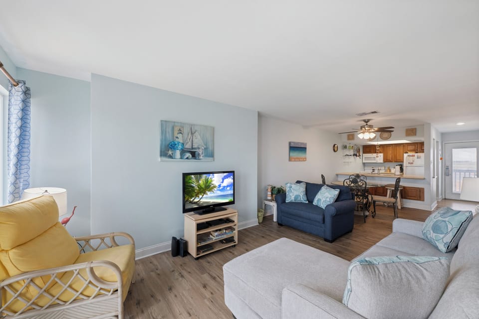 Sink into coastal comfort in your open living space, complete with plush seating, beach-inspired décor, and a smart TV for cozy evenings.