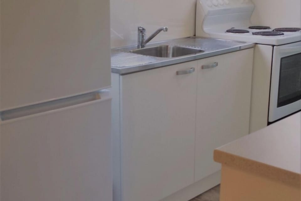 Kitchen has microwave fridge freezer and stove with oven.