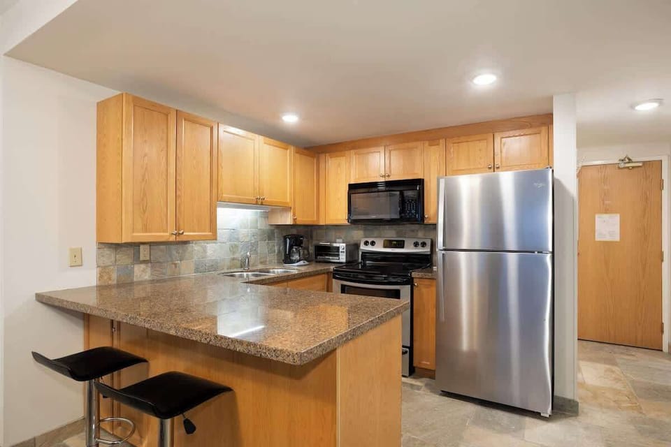 - Modern Whistler kitchen with granite counters and stainless appliances  
- Perfect for cooking after skiing with bar seating and open layout  
- Fully equipped vacation kitchen blending comfort and mountain charm  