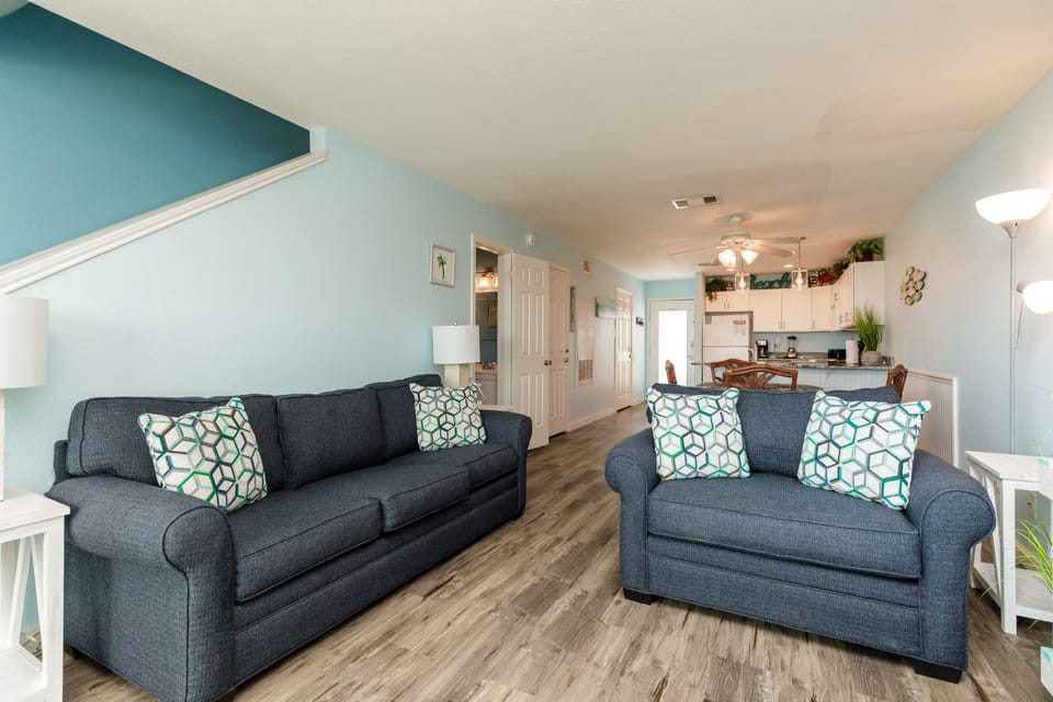 Relax in your spacious living area featuring plush navy sofas, one of which is a queen size sleeper sofa.