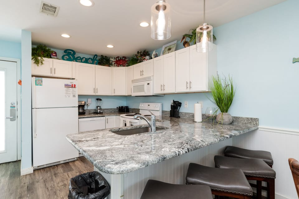 Your fully equipped kitchen invites you to prepare meals while enjoying coastal charm and granite counters.