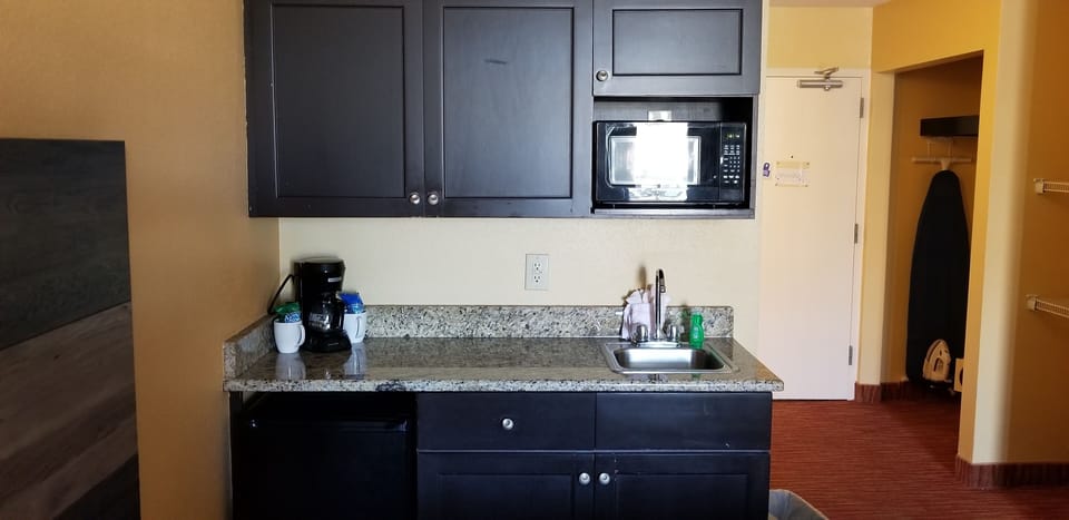 Kitchenette with sink, microwave, and coffee station.