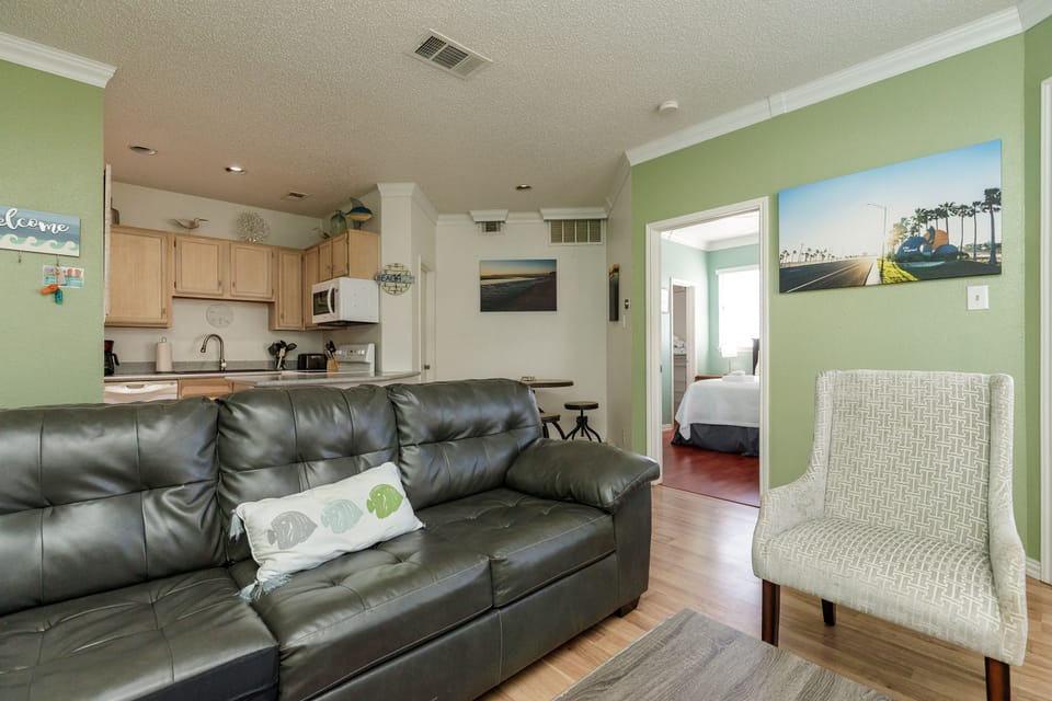 Relax in your bright open-concept living space with comfortable seating, fully equipped kitchen, and tasteful coastal decor throughout.