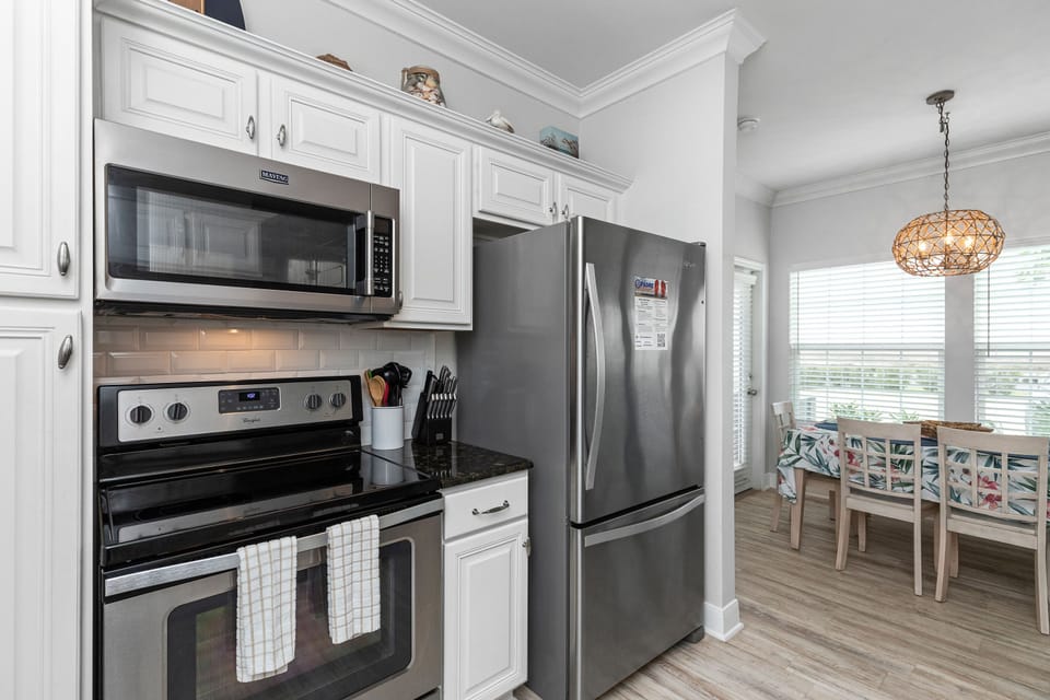 Your fully equipped kitchen features stainless steel appliances and crisp white cabinetry, perfect for preparing meals during your stay.