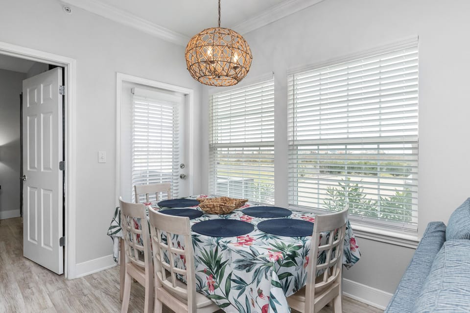 Gather around your bright dining nook, where tropical-print seating and warm woven lighting create the perfect spot for morning coffee or evening meals.