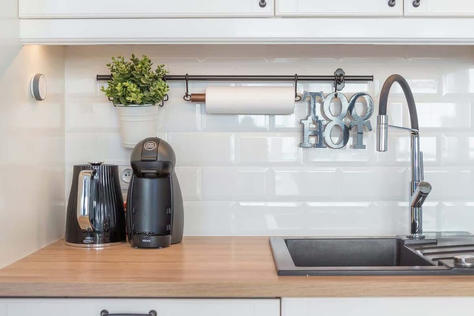 A close-up of the kitchen counter, showcasing a coffee maker, kitchen utensils, and white subway tiles on the backsplash.