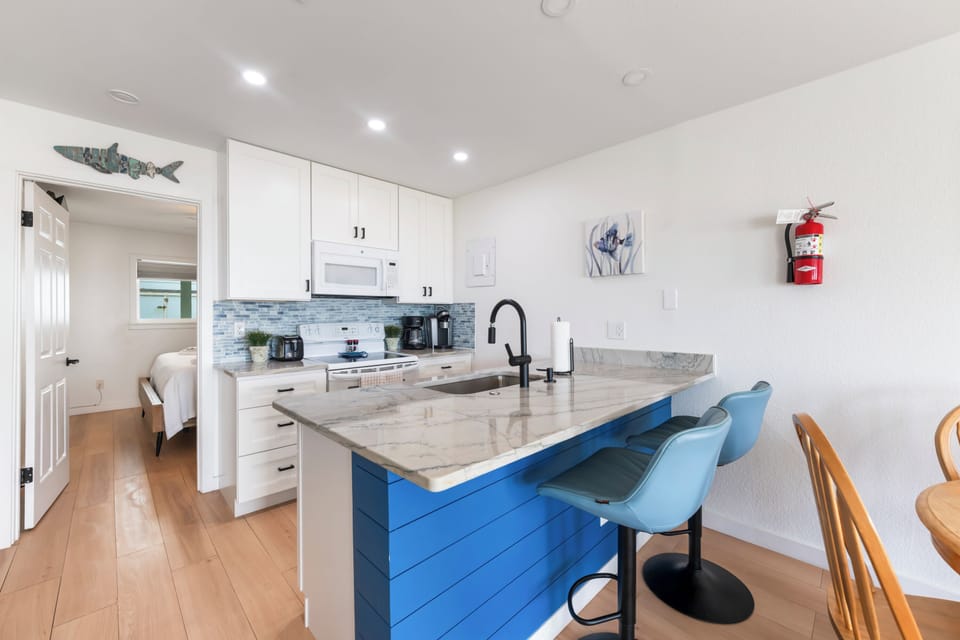 Your bright, modern kitchen comes fully equipped with everything you need to prepare meals at home. Enjoy morning coffee at the island bar, then step into the adjoining bedroom for a peaceful retreat.