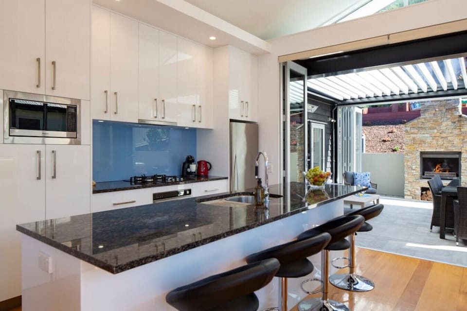 A fully-equipped modern kitchen with coffee machine, dishwasher, oven, cooktop and more
