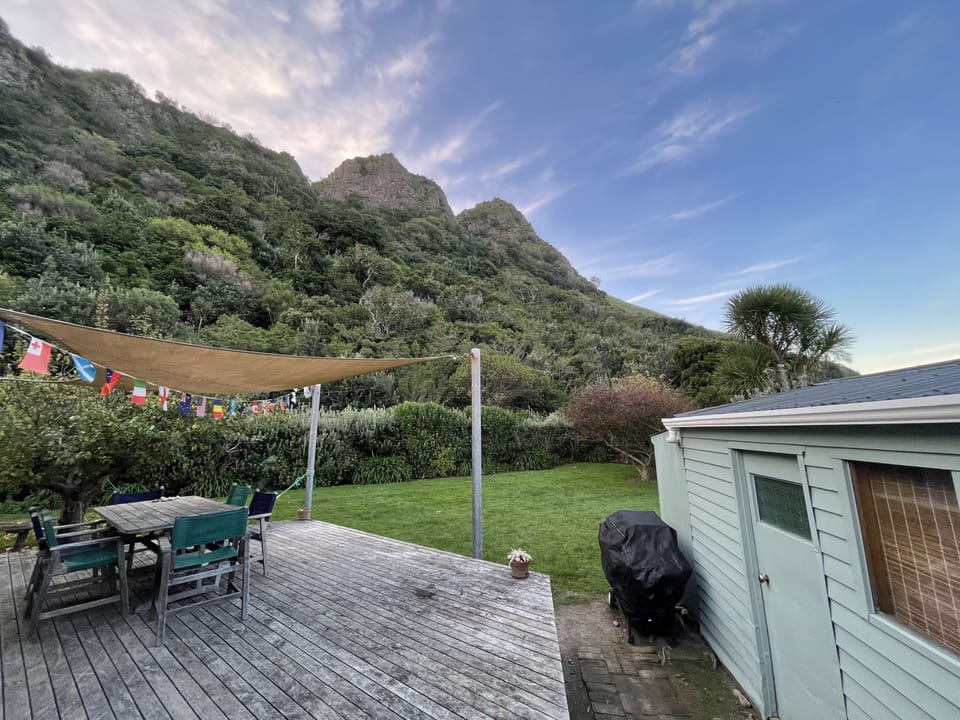 Al fresco dining on the deck with panoramic views of the bush and cliff face. 