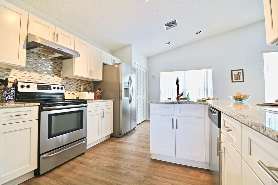 Fully equipped modern kitchen with stainless steel appliances and ample countertop space.